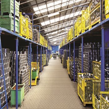 A spacious warehouse aisle lined with metal containers stored on blue and yellow shelves, showcasing industrial storage solutions.